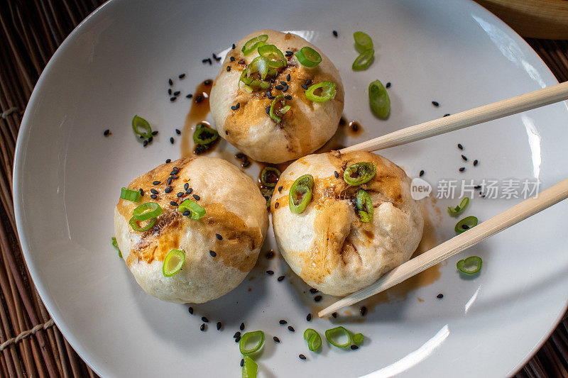 cooked steamed buns with green onions and soy sauce